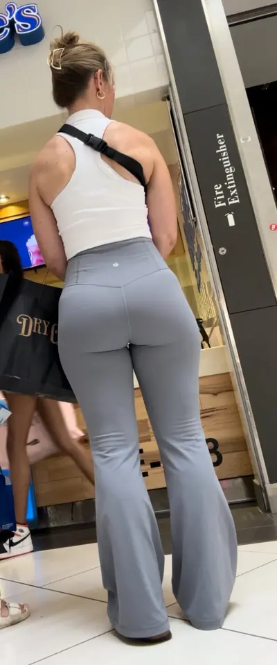 Milf showing her shapely ass in grey leggings at the mall cover image