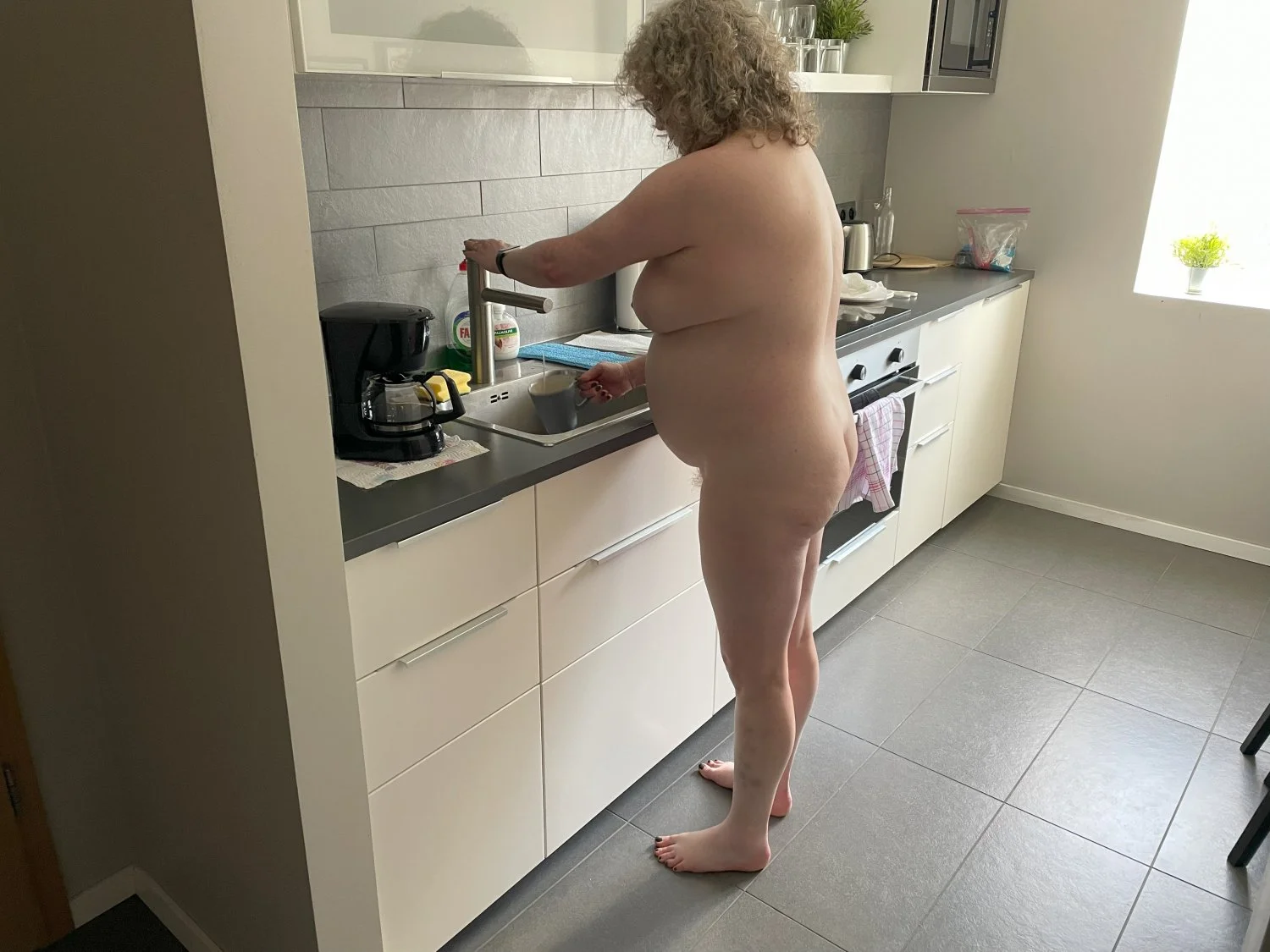 Big belly wife naked in kitchen and unaware image 2
