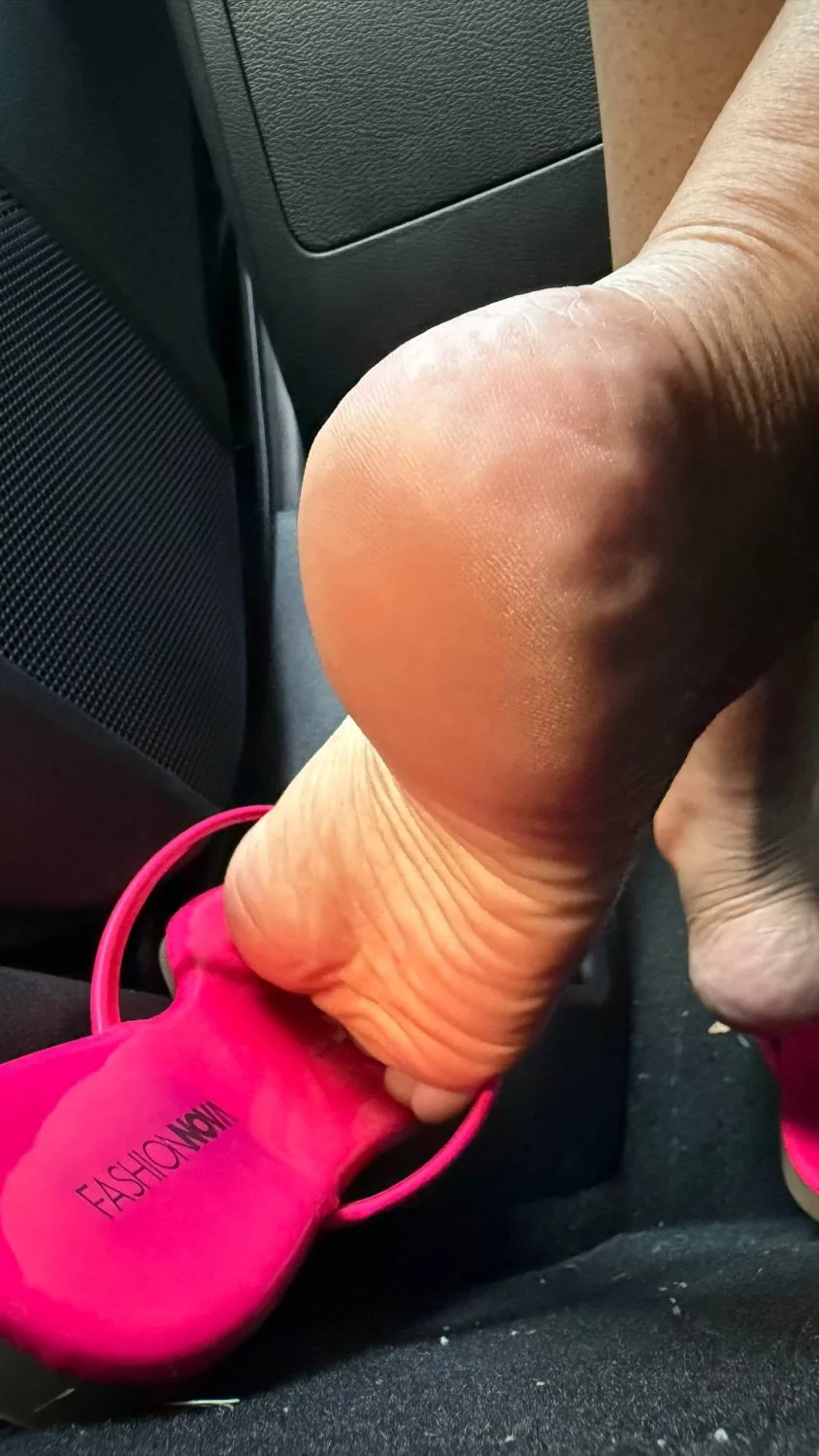 Lightskin MILF showing soles and arches in pink flip flops main image